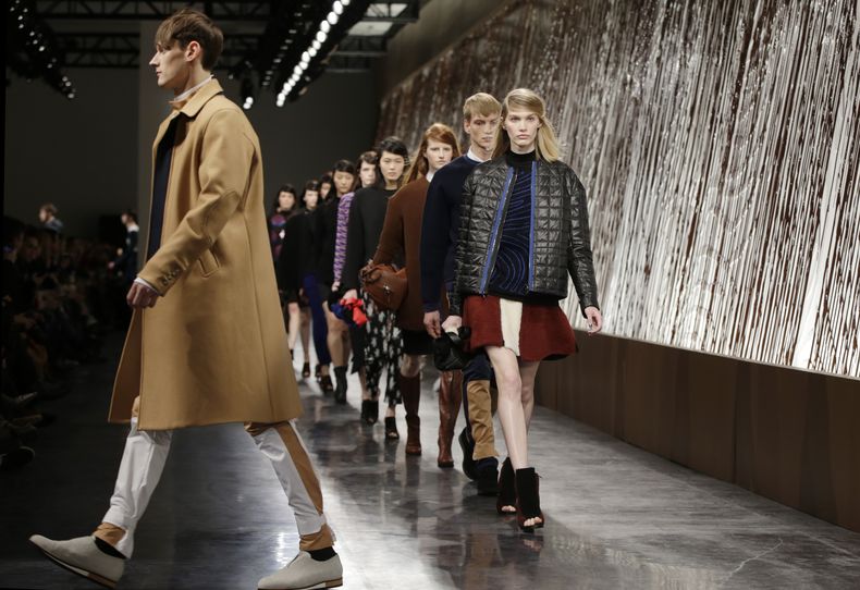Un grupo de modelos desfila mientras jarabe de chocolate desciende por un muro durante la presentaci&oacute;n de la Ceremonia de Apertura de la Semana de Moda de Nueva York el domingo 9 de febrero de 2014. (Foto AP/Kathy Willens)
