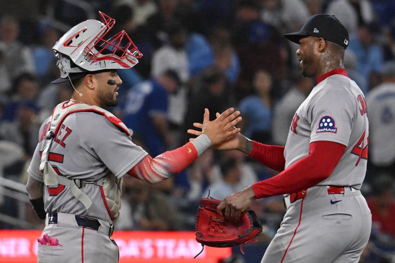 El venezolano Carlos Narváez y el cubano Aroldis Chapman festejan la victoria de los Medias Rojas de Boston sobre los Azulejos de Toronto, el martes 23 de septiembre de 2025 (Jon Blacker/The Canadian Press via AP)