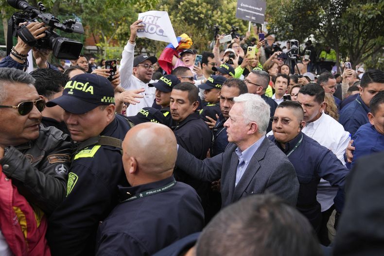 El expresidente colombiano Álvaro Uribe Vélez saluda a simpatizantes el sábado 23 de agosto de 2025 durante una visita al sitio donde el precandidato y senador Miguel Uribe Turbay fue asesinado en un mitin político, en Bogotá, Colombia. (AP Foto/Fernando Vergara)