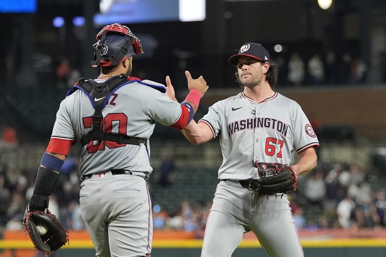 El lanzador de los Nacionales de Washington, Kyle Finnegan, festeja con el receptor Keibert Ruiz después de la décima entrada del juego contra los Tigres de Detroit, el martes 11 de junio de 2024, en Detroit. (AP Foto/Carlos Osorio)