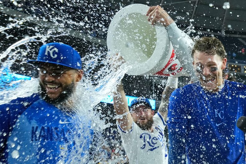 El dominicano Carlos Durán (izquierda) y Bobby Witt Jr. (derecha) son empapados por Kyle Isbel, su compañero de los Reales de Kansas City, tras la victoria sobre los Atléticos, el martes 18 de agosto de 2026 (AP Foto/Charlie Riedel)