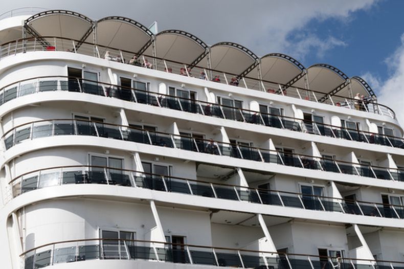 Pasajeros a bordo del crucero británico Ambition luego de que las autoridades francesas ordenaron que sus 1.700 pasajeros y tripulantes permanezcan a bordo por un brote gastrointestinal, en Burdeos, Francia, el 13 de mayo de 2026. (AP Foto/Caroline Blumberg)