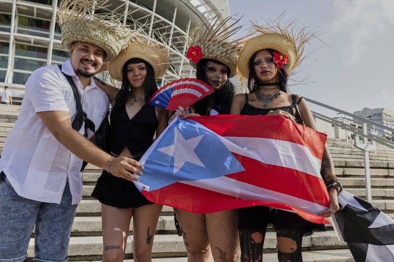 Fans de Bad Bunny posan para una fotografía previo al primero de los 30 conciertos de la residencia del cantante en el Coliseo de Puerto Rico José Miguel Agrelot en San Juan, Puerto Rico, el viernes 11 de julio de 2025. (AP Foto/Alejandro Granadillo)