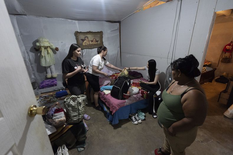 Martha Rosales (derecha), observa mientras migrantes cubanos empacan sus pertenencias tras recibir cita para solicitar asilo en Estados Unidos a través de la aplicación para celulares CBP One, el 28 de agosto de 2024, en Tijuana, México. (AP Foto/Gregory Bull)