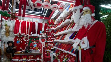 ARCHIVO - Una persona espera a clientes junto a disfraces de Santa Claus en el Mercado Internacional Yiwu en Yiwu, en la provincia oriental china de Zhejiang, el 10 de abril de 2025. (AP Foto/Ng Han Guan, Archivo)