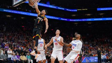 Devin Booker (1), de los Suns de Phoenix, anota un mate frente a sus rivales de los Clippers de Los Ángeles Mason Plumlee (44), Nicolas Batum (33) y Norman Powell (24) durante la segunda mitad del quinto juego de la primera ronda de los playoffs de la NBA, el 25 de abril de 2023, en Phoenix. (AP Foto/Matt York)