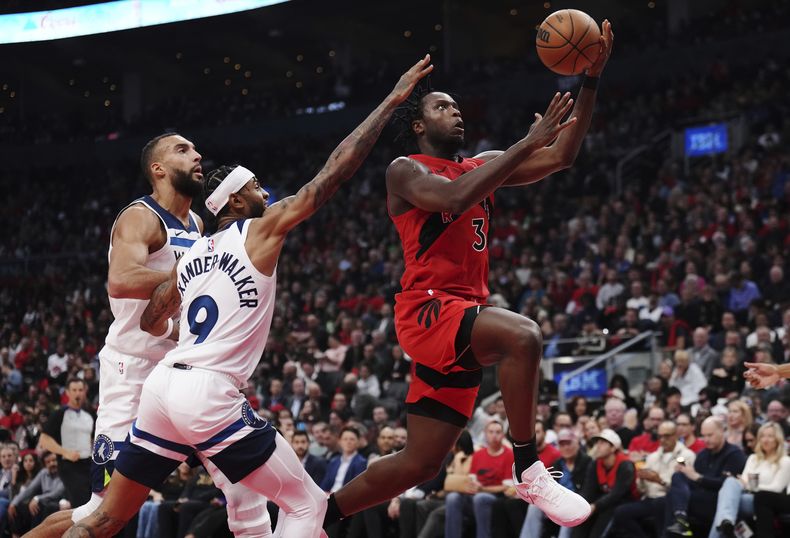 O.G. Anunoby, de los Raptors de Toronto, salta hacia la cesta frente a Nickeil Alexander-Walker, de los Timberwolves de Minnesota, en el duelo del miércoles 25 de octubre de 2023 (Nathan Denette/The Canadian Press via AP)