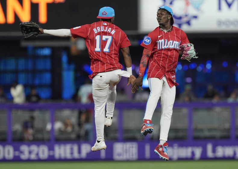 El campocorto de los Marlins de Miami, Vidal Bruján (17), y el jardinero central Jazz Chisholm Jr., a la derecha, celebran al final de un juego contra los Medias Blancas de Chicago, el sábado 6 de julio de 2024, en Miami. (AP Foto/Marta Lavandier)