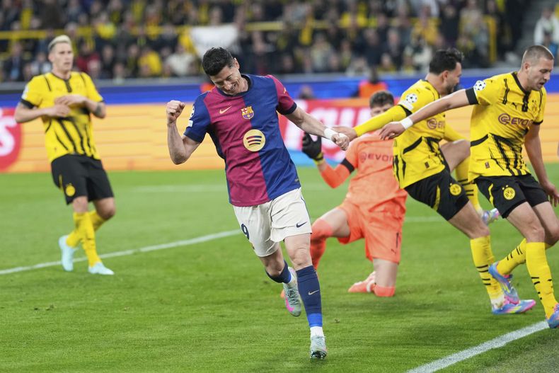 Robert Lewandowski del Barcelona celebra tras forzar un autogol de Ramy Bensebaini en el encuentro de vuelta de los cuartos de final de la Liga de Campeones ante el Borussia Dortmund el martes 15 de abril del 2025. (AP Foto/Matthias Schrader)
