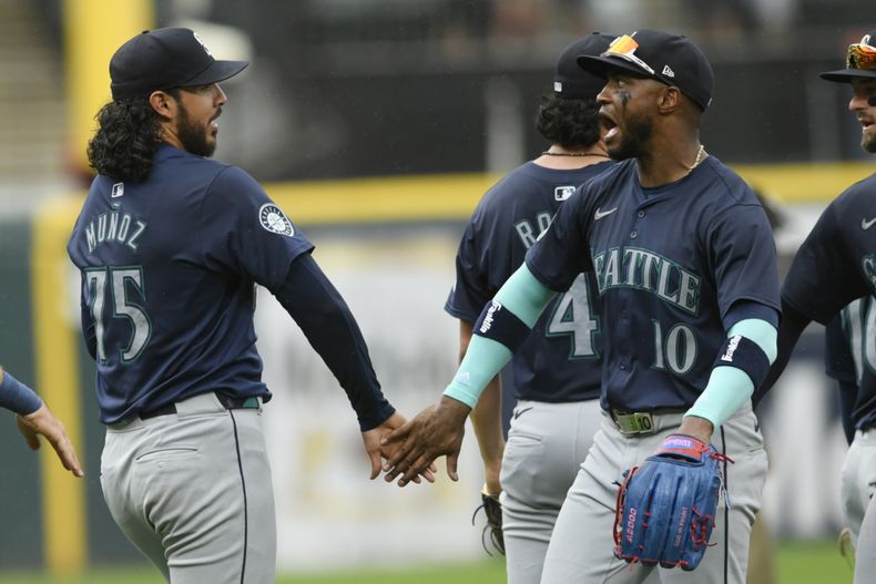 El cerrador mexicano de los Marineros de Seattle, Andrés Muñoz (75) celebra junto a su compañero de equipo, el dominicano Víctor Robles (10) luego de vencer a los Medias Blancas de Chicago, en el juego de béisbol en Chicago, el domingo 28 de julio de 2024. (AP Foto/Paul Beaty)
