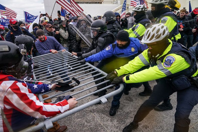 ARCHIVO - Partidarios de Trump intentan romper una barrera policial, el 6 de enero de 2021, en el Capitolio, en Washington. (Foto AP/John Minchillo, Archivo)
