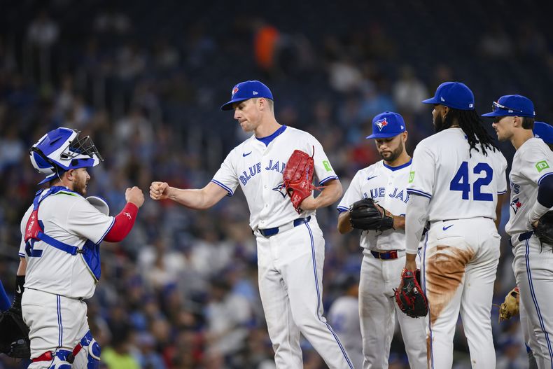 El lanzador de los Azulejos de Toronto, Chris Bassitt, segundo desde la izquierda se despide del receptor mexicano Alejandro Kirk, tras ser relevado durante la séptima entrada de un juego de béisbol contra los Yankees de Nueva York en Toronto el lunes 15 de abril de 2024. (Christopher Katsarov/The Canadian Press vía AP)