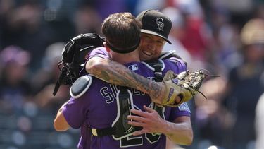 Kyle Freeland, derecha, abridor de los Rockies de Colorado, abraza al receptor Brett Sullivan, después de que forzara a un out con un elevado a Tyler Tolbert para terminar el juego con al lanzar la ruta completa, en el juego de béisbol de Grandes Ligas del domingo 2 de agosto de 2026, en Denver. (AP Foto/David Zalubowski)