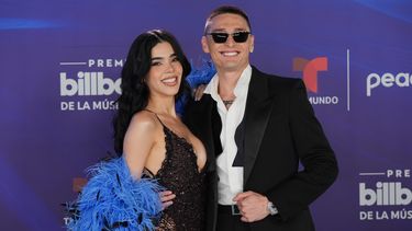Kenia Os, izquierda, y Peso Pluma llegan a los Premios Billboard de la Música Latina el jueves 23 de octubre de 2025, en Miami. (Foto AP/Marta Lavandier)