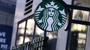 El logotipo de la Sirena cuelga fuera de una cafetería Starbucks, el miércoles 14 de julio de 2021, en Boston. (AP Foto/Charles Krupa)