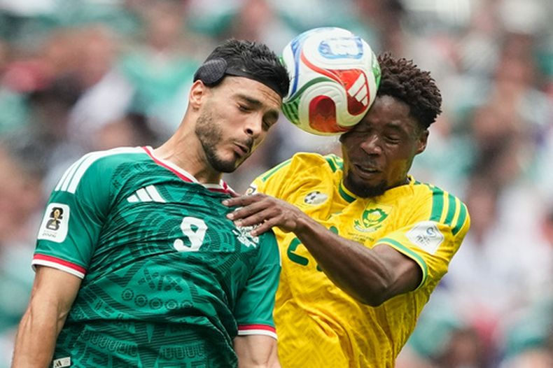El mexicano Raúl Jiménez, a la izquierda, salta por el balón con el sudafricano Ime Okon durante el partido de fútbol del Grupo A de la Copa Mundial entre México y Sudáfrica en la Ciudad de México, el jueves 11 de junio de 2026. (Foto AP/Natacha Pisarenko)
