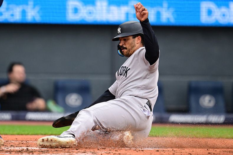 Trent Grisham, de los Yankees de Nueva York, anota gracias a un error de lanzamiento de Brayan Rocchio, de los Guardianes de Cleveland, durante la tercera entrada del juego de béisbol de Grandes Ligas, el lunes 8 de junio de 2026, en Cleveland. (AP Foto/David Dermer)