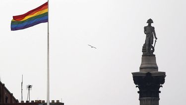 La bandera del arcoíris, símbolo de la comunidad lésbica, gay, bisexual y transgénero, ondea sobre un edificio junto al monumento de Nelson en Trafalgar Square en el centro de Londres, Gran Bretaña, el viernes 28 de marzo de 2014. (AP Foto/Lefteris Pitarakis, Archivo)