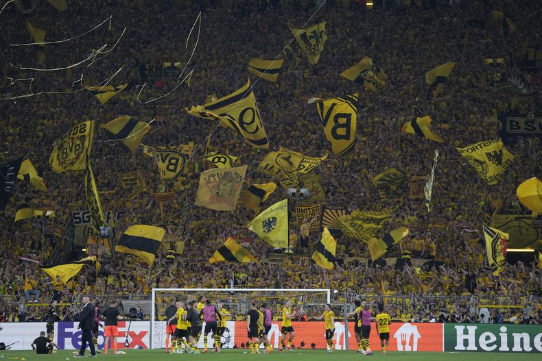 Los seguidores del Borussia Dortmund agitan banderas en el partido de ida de las semifinales de la Liga de Campeones ante el París Saint-Germain, el miércoles 1 de mayo de 2024 (AP foto/Matthias Schrader)