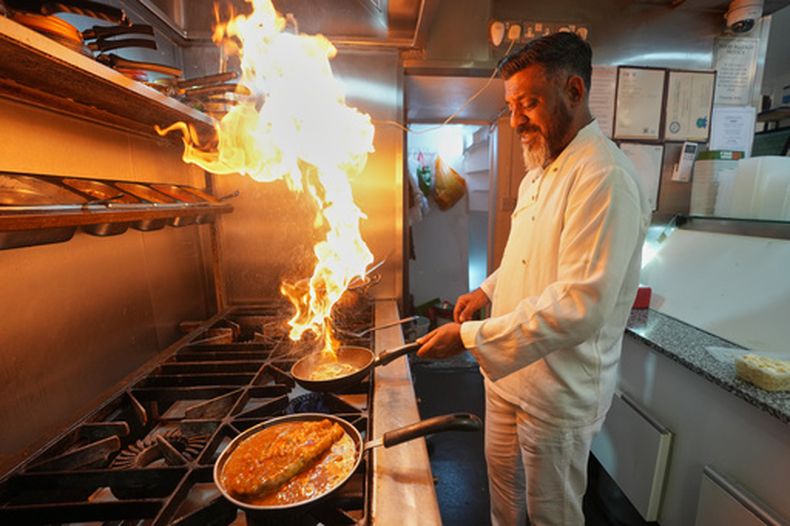 El chef Mohammed Shanoor Ali cocina en un restaurante bangladesí en Londres, el 18 de junio del 2026. (AP foto/Kin Cheung)