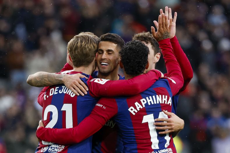 Frenkie de Jong (21), celebra con sus compañeros después de anotar el tercer gol de su equipo durante el partido de fútbol de la Liga de España entre Barcelona y Getafe en el estadio olímpico Lluis Companys, en Barcelona, España, el sábado 24 de febrero de 2024. (AP Foto/Joan Monfort)