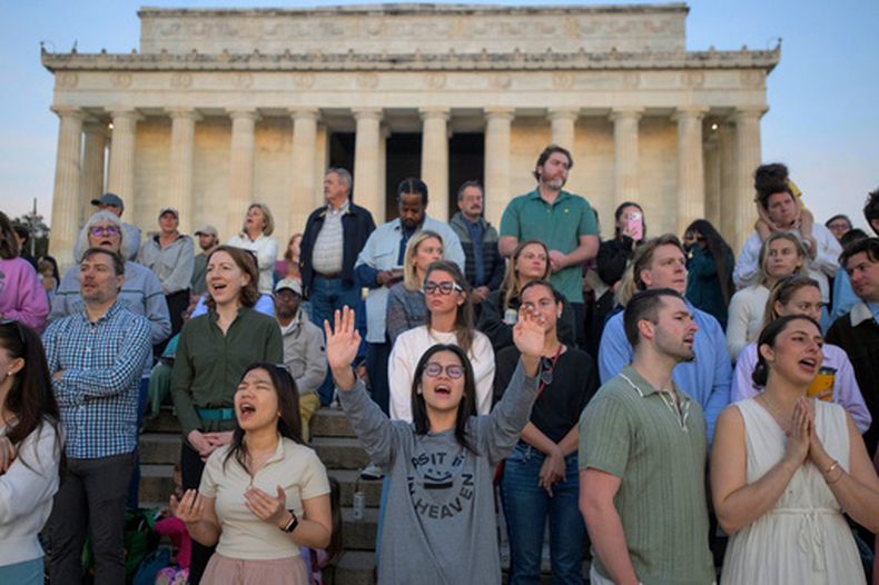 Gente levanta las manos al cielo en canto durante un servicio de oración al amanecer del Domingo de Pascua en el Lincoln Memorial, el 5 de abril de 2026, en Washington. (Foto AP/Rod Lamkey, Jr.)