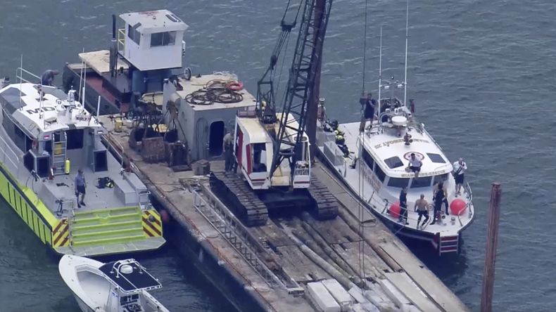 Esta imagen, tomada de un video proporcionado por la televisora WSVN-TV, muestra a los bomberos de Miami-Dade y otras personas en botes junto a lo que parece ser una barcaza involucrada en un choque contra un grupo de niños y un adulto en un bote de vela, el lunes 28 de julio de 2025, en Miami. (WSVN-TV vía AP)