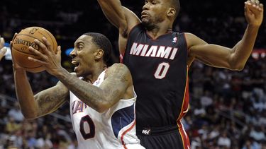americateve | Jeff Teague, de los Hawks de Atlanta, salta hacia la cesta frente a Toney Douglas, del Heat de Miami, en el encuentro del s&aacute;bado 12 de abril de 2014 (AP foto/John Amis)