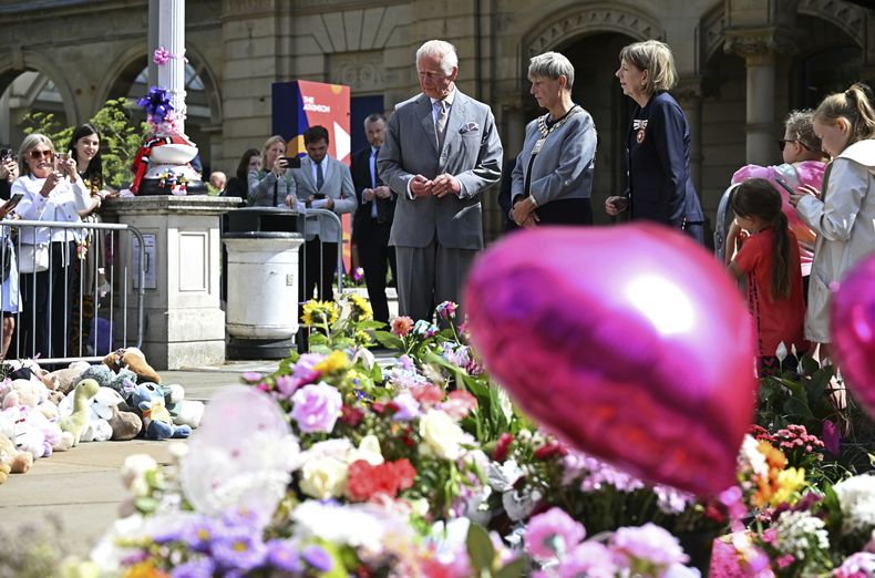 El rey Carlos III de Gran Bretaña mira ofrendas frente al Ayuntamiento de Southport, en Southport, Inglaterra, el martes 20 de agosto de 2024, mientras se reúne con miembros de la comunidad local, luego del ataque del 29 de julio en una clase de baile infantil. (Paul Ellis/Pool vía AP)