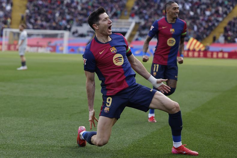 Robert Lewandowski del Barcelona celebra junto a Raphinha tras abrir el marcador en el encuentro de la liga española ante el Alavés el domingo 2 de febrero del 2025. (AP Foto/Joan Monfort)