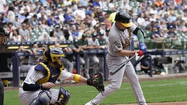 El cubano Aledmys Díaz, de los Atléticos de Oakland, batea un sencillo en el duelo del sábado 10 de junio de 2023, ante los Cerveceros de Milwaukee (AP Foto/Morry Gash)