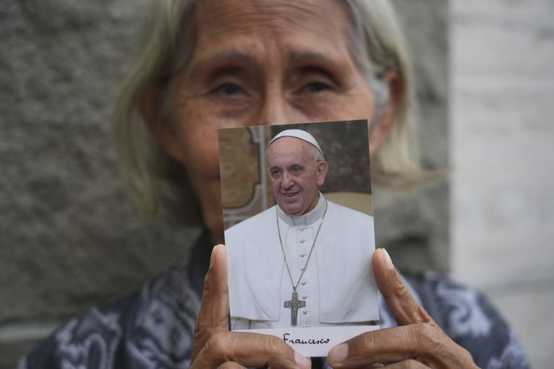 Una mujer muestra una imagen del fallecido papa Francisco ante la Nunciatura Apostólica en Yakarta, Indonesia, el 22 de abril de 2025. (AP Foto/Tatan Syuflana)