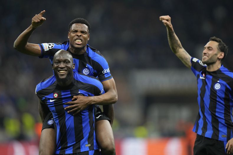 Romelu Lukaku, abajo, y sus compañeros del Inter de Milán Denzel Dumfries, arriba, y Hakan Calhanoglu, celebran el final del partido de vuelta de las semifinales de la Liga de Campeones ante el Milan, el martes 16 de mayo de 2023, en Milán. (AP Foto/Luca Bruno)