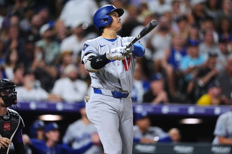 Shohei Ohtani, de los Dodgers de Los Ángeles, observa el vuelo de la pelota en su jonrón de dos carrers frente a los Rockies de Colorado, el lunes 17 de agosto de 2026, en Denver. (AP Foto/David Zalubowski)