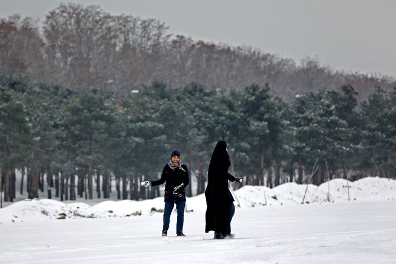 Un iran&iacute; lanza una bola de nieve contra su esposa en Teher&aacute;n, Ir&aacute;n, el martes 4 de febrero de 2014. Muchas partes e Ir&aacute;n est&aacute;n cubiertas por la nieve. Debido a las temperaturas g&eacute;lidas, tres personas murieron cuan