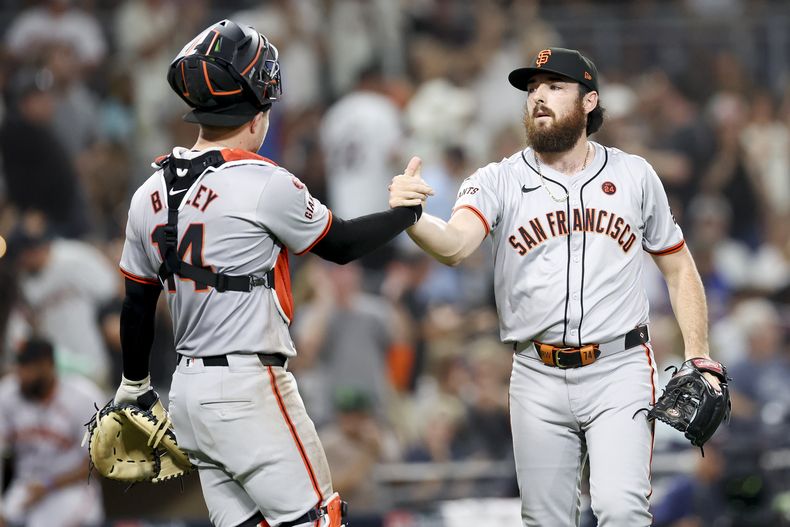 El lanzador relevista de los Gigantes de San Francisco, Ryan Walker, a la derecha, y el receptor Patrick Bailey, a la izquierda, celebran después del último out contra los Padres de San Diego, el sábado 7 de septiembre de 2024, en San Diego. (AP Foto/Ryan Sun)