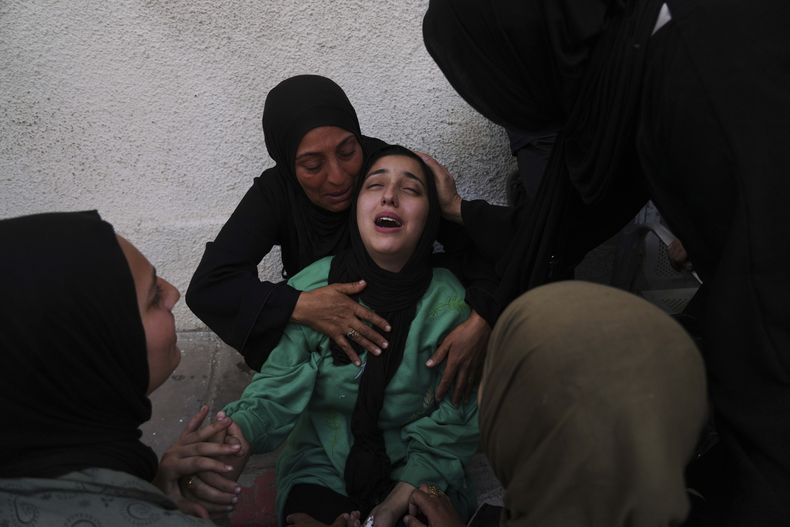 Walaa Al-Kilani, en el centro, llora a su madre y a su hermano, muertos en un ataque aéreo israelí en una escuela convertida en refugio para desplazados, en el Hospital Al-Shifa de Ciudad de Gaza, el lunes 26 de mayo de 2025. (AP Foto/Jehad Alshrafi)