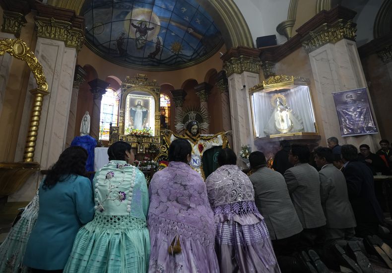 Devotos rezan después de vestir la estatua de Jesús del Gran Poder en la iglesia Jesús del Gran Poder en La Paz, Bolivia, el jueves 1 de junio de 2023. (AP Foto/Juan Karita)