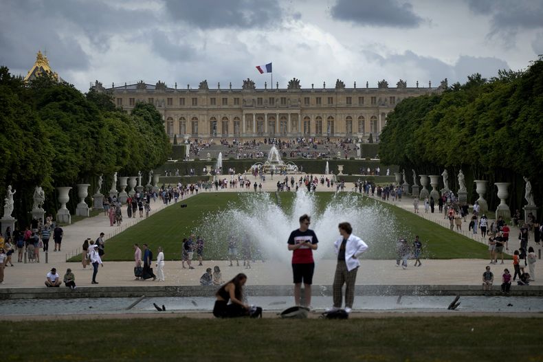 Turistas vistan el Palacio de Versalles y sus jardines en las afueras de París, 15 de julio de 2023. (AP Foto/Christophe Ena, Archivo)