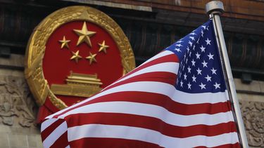 ARCHIVO – Una bandera estadounidense ondea cerca del emblema nacional de China, fuera del Gran Salón del Pueblo, en Beijing, el 9 de noviembre de 2017. (AP Foto/Andy Wong, Archivo)