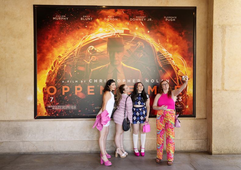 De izquierda a derecha, Gabrielle Roitman, Kayla Seffing, Maddy Hiller y Casey Myer se toman una selfie enfrente de un cartel de Oppenheimer antes de asistir a una función de Barbie, el jueves 20 de julio de 2023, en el cine AMC The Grove 14 en Los Ángeles. (Foto AP/Chris Pizzello)