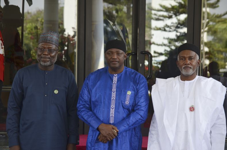 Omar Touray, izquierda, presidente de la Comisión de la ECOWAS, el presidente de Gambia, Adama Barrow, centro, y el ministro de Relaciones Exteriores de Nigeria, Yusuf Tuggar, posan para una foto antes del inicio de la cumbre de ECOWAS en Abuya, Nigeria, el domingo 15 de diciembre de 2024. (AP Foto/Olamikan Gbemiga)