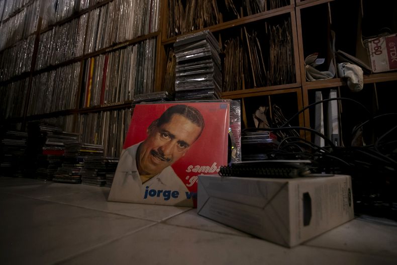 La portada del álbum Samba E Ginga de 1963 de Jorge Veiga apoyada contra un estante lleno de la colección de música de Carlos Savalla, en su estudio en Río de Janeiro, Brasil, el viernes 19 de abril de 2024. Savalla, un productor musical de 66 años en Río, Posee más de 60.000 discos de vinilo. (Foto AP/Bruna Prado)