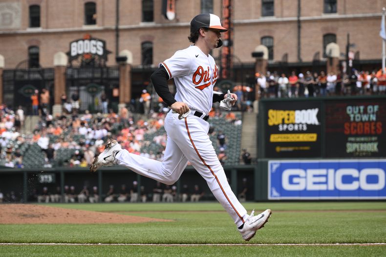 Adley Rutschman de los Orioles de Baltimore anota una carrera ante los Rangers de Texas, el domingo 28 de mayo de 2023. (AP Foto/Nick Wass)