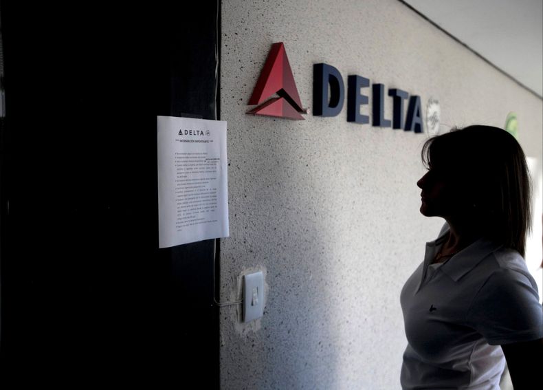 Archivo - En esta fotograf&iacute;a de archivo del 24 de enero de 2014 una mujer lee un letrero en la oficina cerrada de Delta Airlines en Caracas, Venezuela. Delta Air Lines anunci&oacute; que reducir&aacute; a partir de agosto en 85% sus vuelos a Venezu