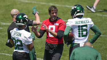 Aaron Rodgers, centro, quarterback de los Jets de Nueva York, platica con sus compañeros de equipo durante un ejercicio en el campo de entrenamiento de la NFL en las instalaciones del equipo en Florham Park, Nueva Jersey, el miércoles 31 de mayo de 2023. (AP Foto/Seth Wenig)