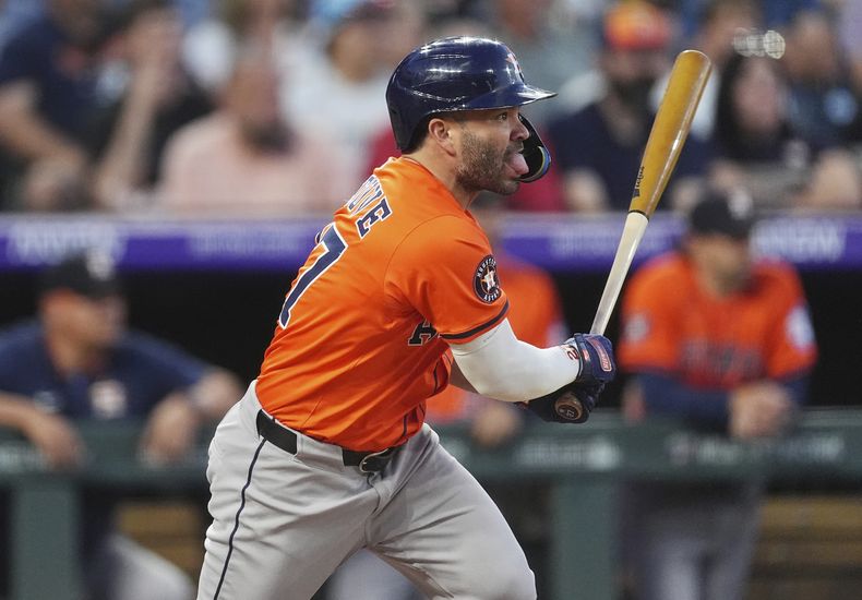 José Altuve, de los Astros de Hpuston, sigue el vuelo de la pelota de un sencillo que produjo dos carreras ante el relevista de los Rockies de Houston, Jake Bird, en la sexta entrada del juego de béisbol de Grandes Ligas el miércoles 2 de julio de 2025, en Denver. (AP Foto/David Zalubowski)