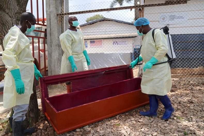 Trabajadores de salud que forman parte de un equipo de entierros dignos y seguros desinfectan un ataúd para enterrar a Abineno Justine, una mujer de 38 años que murió de ébola en Bunia, República Democrática del Congo, el viernes 4 de septiembre de 2026. (AP Foto/Dieudonne Dirole)