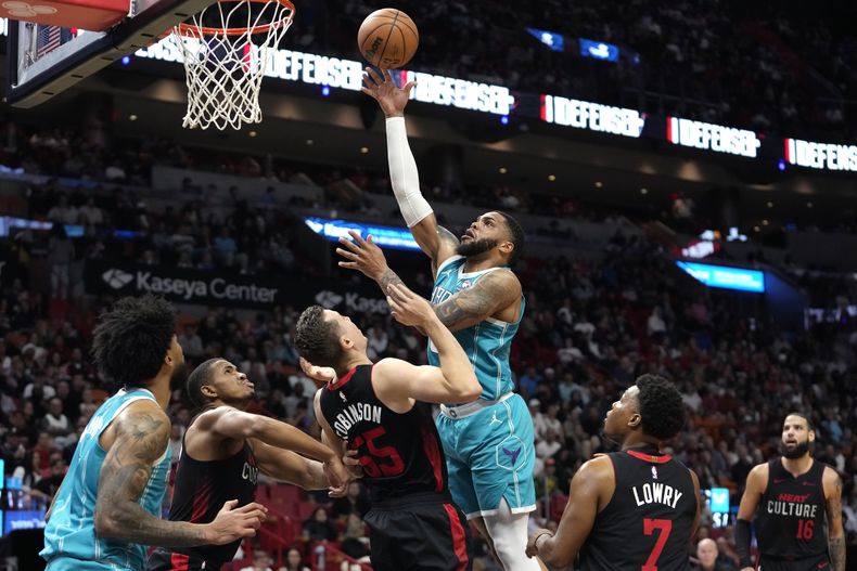 Miles Bridges, de los Hornets de Charlotte, realiza un tiro sobre Duncan Robinson (55), del Heat de Miami, durante la segunda mitad del juego de baloncesto de la NBA, el miércoles 13 de diciembre de 2023, en Miami. (AP Foto/Lynne Sladky)