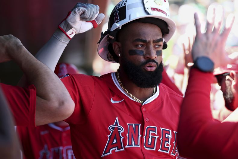 Jo Adell, de los Angelinos de Los Ángeles, celebra en la caseta después de batear un cuadrangular de tres carreras durante la primera entrada del juego de béisbol de Grandes Ligas frente a los Atléticos, el domingo 17 de agosto de 2025, en West Sacramento, California. (AP Foto/Sara Nevis)
